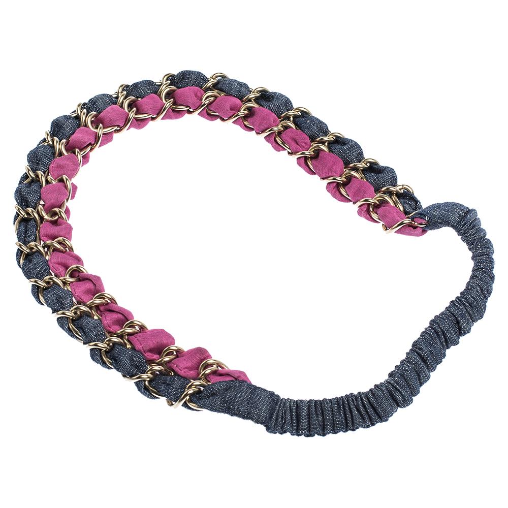 This Chanel headband creates a look that you can easily call your crowning glory. It is made from colorful fabric and designed in a signature style with interwoven metal chainlink as well as CC charm. Wear it with your off-duty