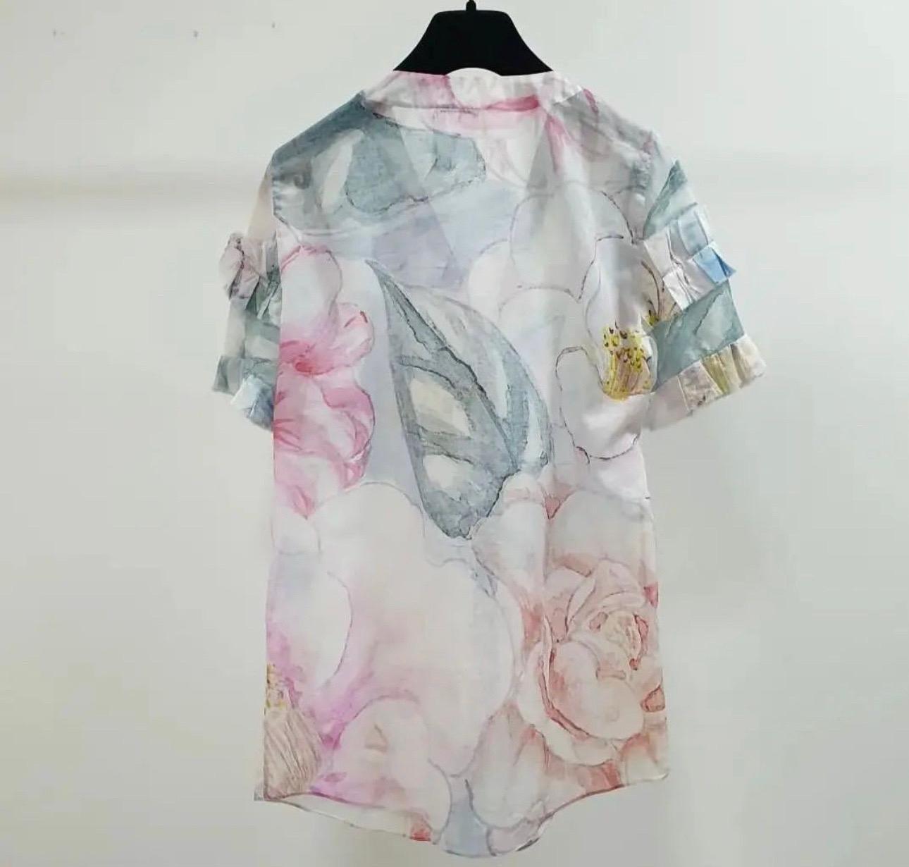 Perfect for spring summer and easy to dress up and down through the day, this Chanel  blouse is a must have feminine fashion piece.
Designed in multicoloured floral watercolour print cotton fabric, this blouse features a collar and concealed button