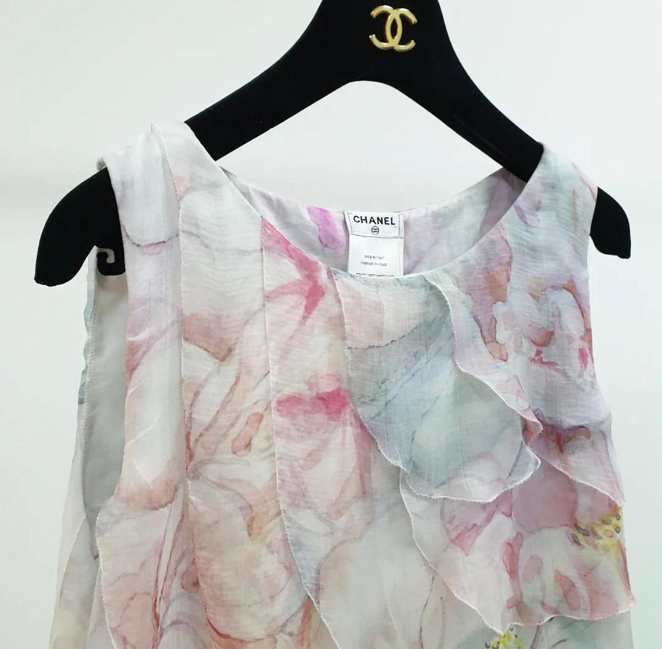 Diese ärmellose Bluse von Chanel ist perfekt für den Frühling und den Sommer und lässt sich den ganzen Tag über tragen. Sie ist ein unverzichtbares Stück femininer Mode.
Diese Bluse aus Baumwollstoff mit mehrfarbigem Blumendruck und Aquarellmuster