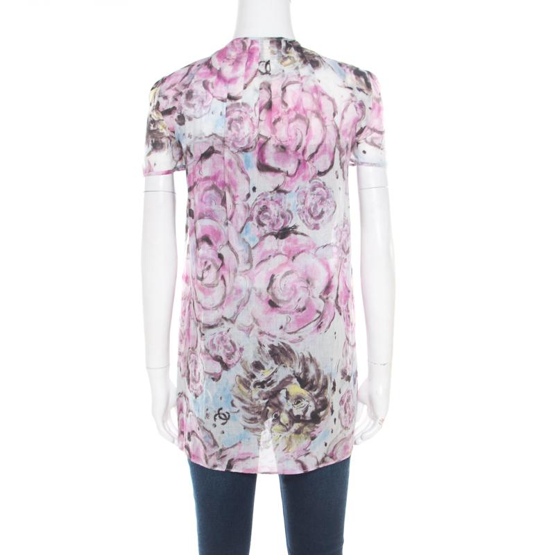 How lovely is this blouse from Chanel! The multicolour creation is made of 100% cotton and features a floral print all over it. It flaunts an open front silhouette, a neck-tie detailing and short sleeves. It is sure to lend you a flattering fit and