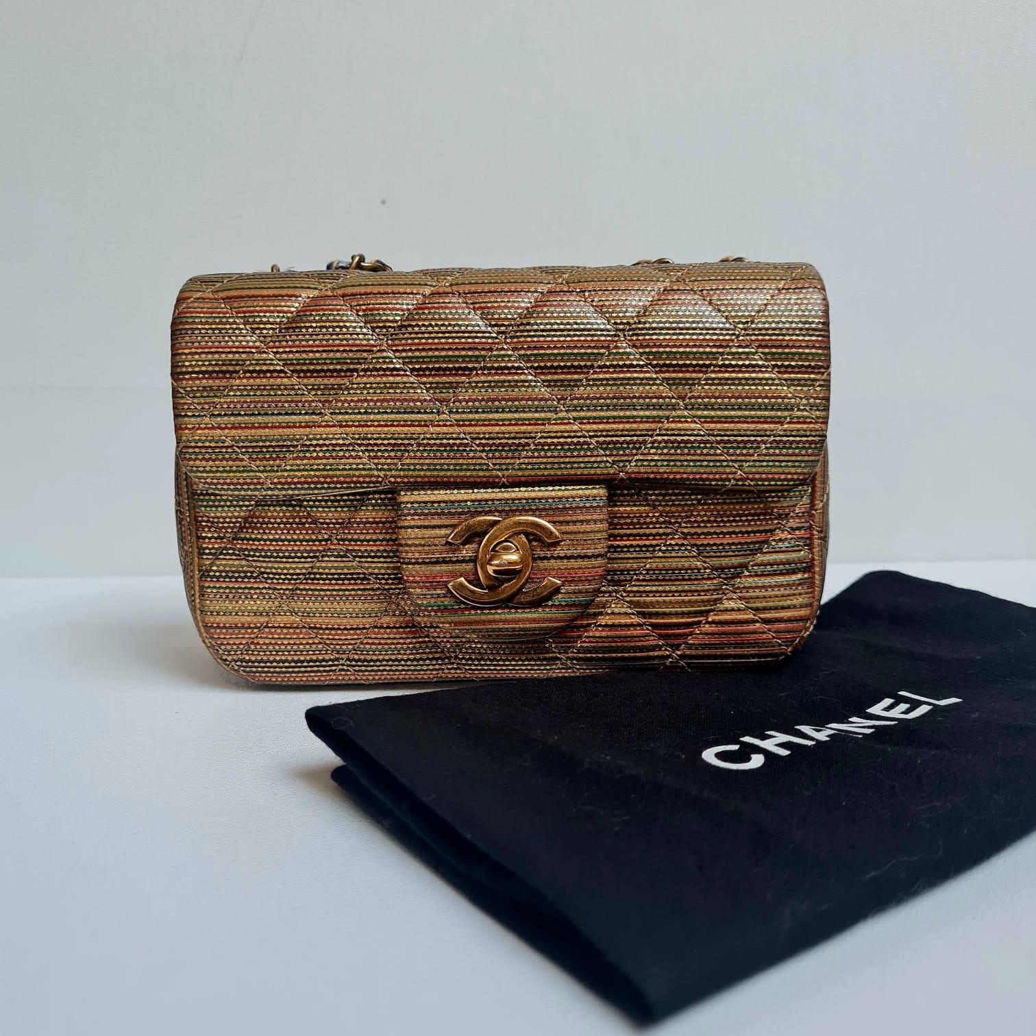 Beautiful mini flap bag in metalic raffia woven material. Perfect mini size. Light tackiness on the exterior material. Slight pulling on one side of the interwoven chain as seen on picture. Series #21. Bag with holo and dust bag only.