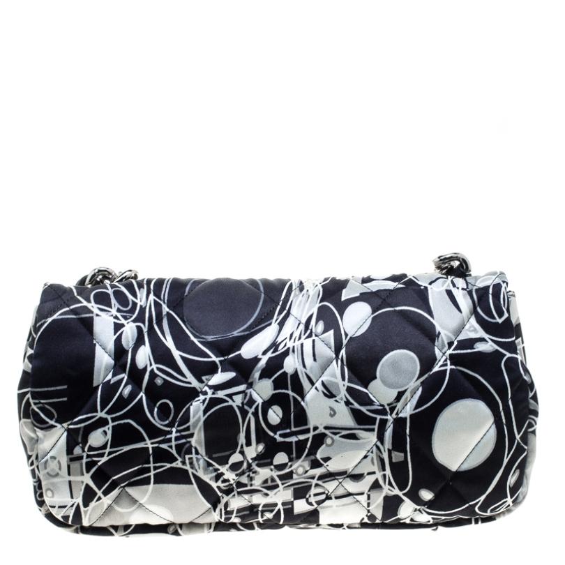 This Chanel flap shoulder bag can add a dash of jazz to any plain outfit. Its nylon multicoloured printed exterior is coupled with the signature quilted stitch, giving it a puffed bubble-like look. The exterior is further beautified with