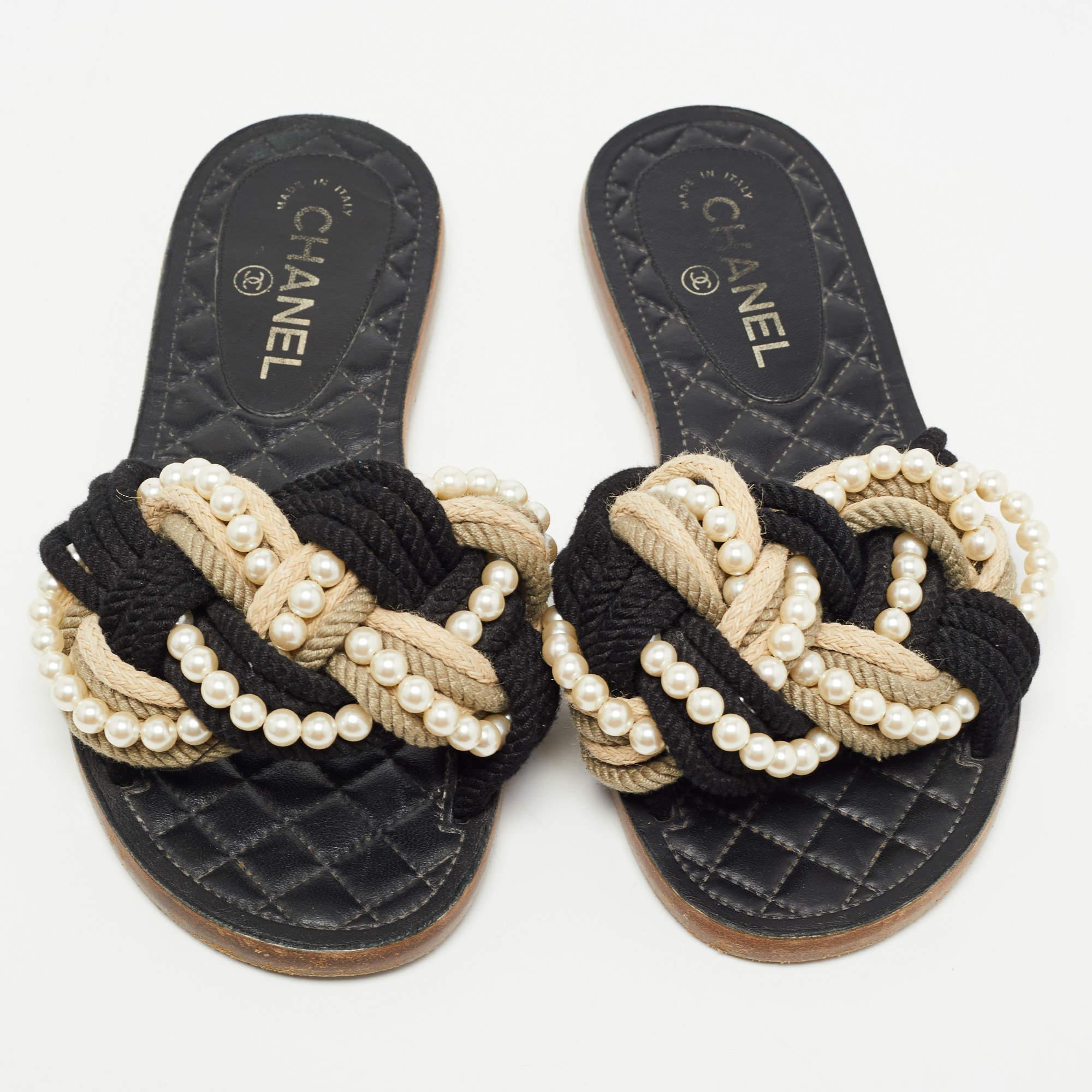 Dress up your outfits with these beautiful Chanel slides that are easy to wear and effortlessly stylish. Constructed in woven ropes, these slides feature decorative faux pearls for a signature look. They are set on durable soles.

