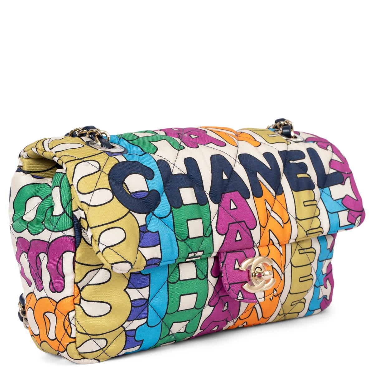 100% authentic Chanel flap bag in rainbow logo pinted silk satin featuring light gold-tone hardware and classic CC turn-lock. The design features navy blue leather and metal chain-link shoulder strap and is lined in navy blue quilted grosgrain with