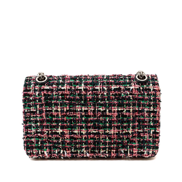 This authentic Chanel Multicolored Tweed Reissue Flap Bag is in excellent plus condition.  The Reissue in tweed is lovely and sophisticated in a spectacular fusion of color.  
Black, green and pink tweed fabric is quilted in signature Chanel diamond