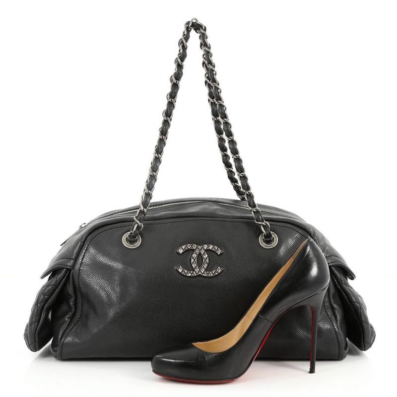 This authentic Chanel Multipocket Bowling Bag Caviar Small showcases timeless design with luxurious, modern edge. Crafted from black caviar leather, this chic bowling bag features woven-in leather chain straps, exterior side pockets with diamond