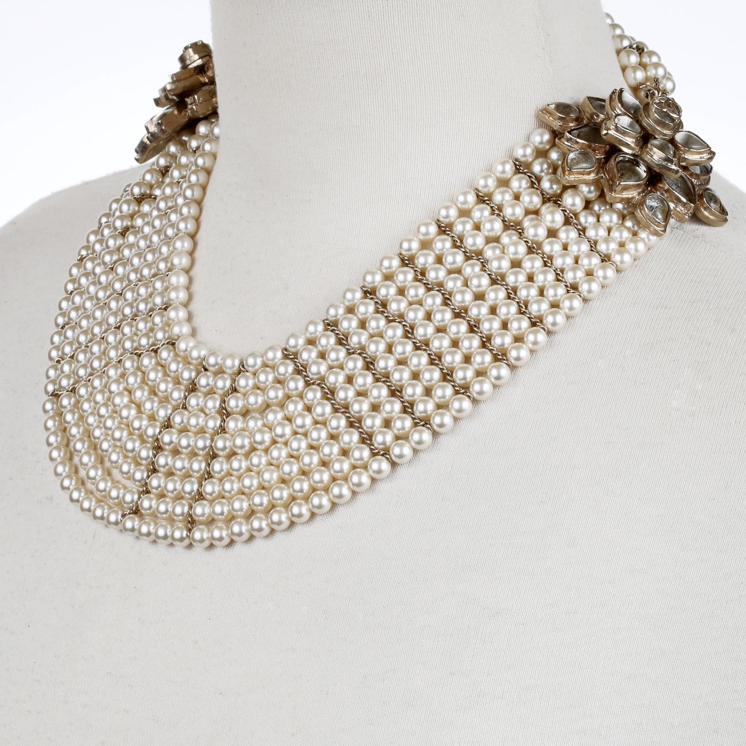 This authentic Chanel Multistrand Pearl Bib Necklace is in excellent condition.  A couture runway piece, this striking choker is certain to become a favorite in any collection.   
Nine strands of faux pearls drape beautifully in this dramatic bib
