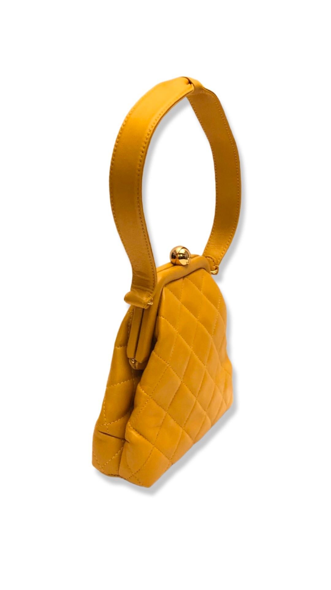 - Vintage Chanel mustard yellow quilted lambskin purse handbag from year 1994-1996 collection. 

- CC gold hardware kiss-lock closure. 

- One slip pocket closure. 

- 16cm x 16cm c 5cm. Handle drop: 20cm.

- Comes with authenticity card, serial