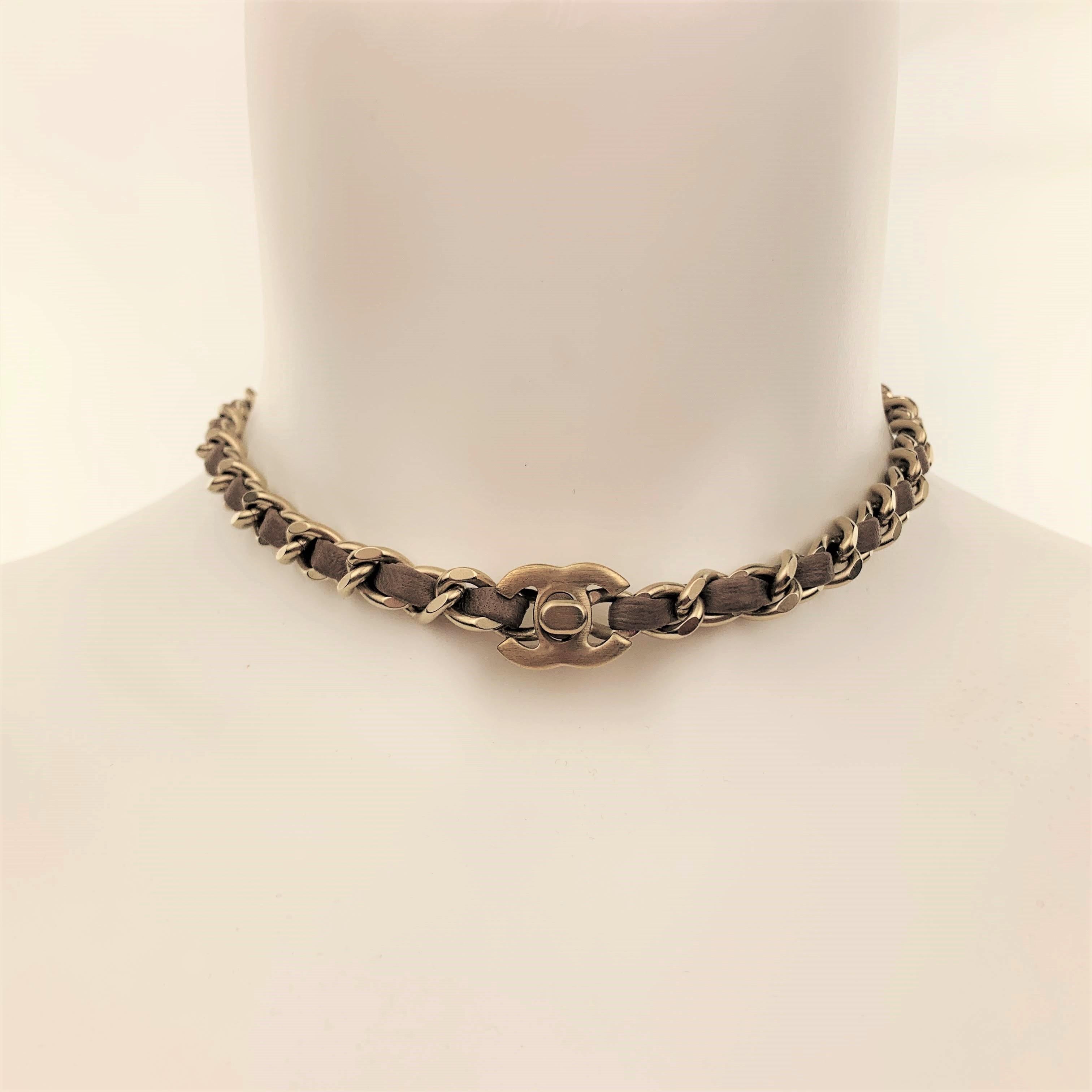 CHANEL circa 2012 choker necklace comes in muted gold tone matte metal with a chain strap woven with taupe leather and CC logo turn lock closure. Made in Italy.
 
Excellent Pre-Owned Condition.
Marked: 12 P
 
Length: 15 in.
Width: 0.75 cm.