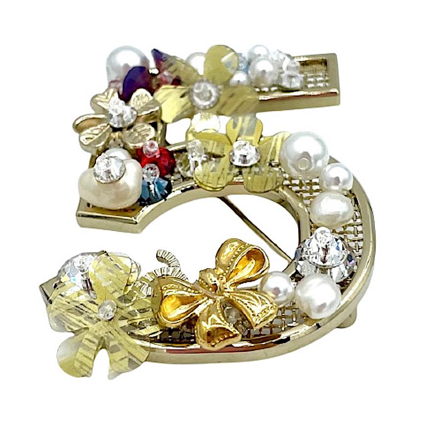 CHANEL Brooch n 5 flowers, in gilt metal, pearls, and rhinestones.
In very good condition
Made in France.
Dimensions: 5 x 3.5 cm
Presence of stamp on the back of the brooch.
Collection Fall 2020.

Will be delivered in a non-original dustbag.