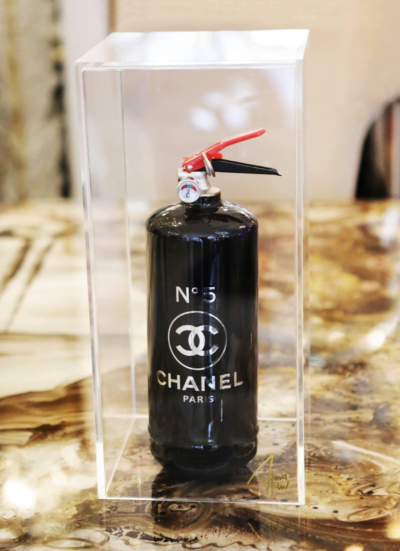 Extinguisher Chanel N°5 black edition Glossy. 
Limited edition of 16 pieces. Exceptional piece. 
Under plexiglass box.
Box: L 20 x D 20 x H 42.5cm.
Extinguisher: L 10.5 x D 10.5 x H 35.5cm.
 