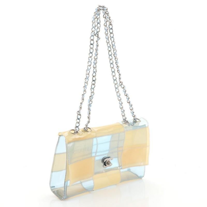 This Chanel Naked Patchwork Flap Bag PVC Medium, crafted in blue and neutral PVC, features a chain-link shoulder strap, frontal flap and matte silver-tone hardware. Its CC turn-lock closure opens to a blue and neutral PVC interior. Hologram sticker