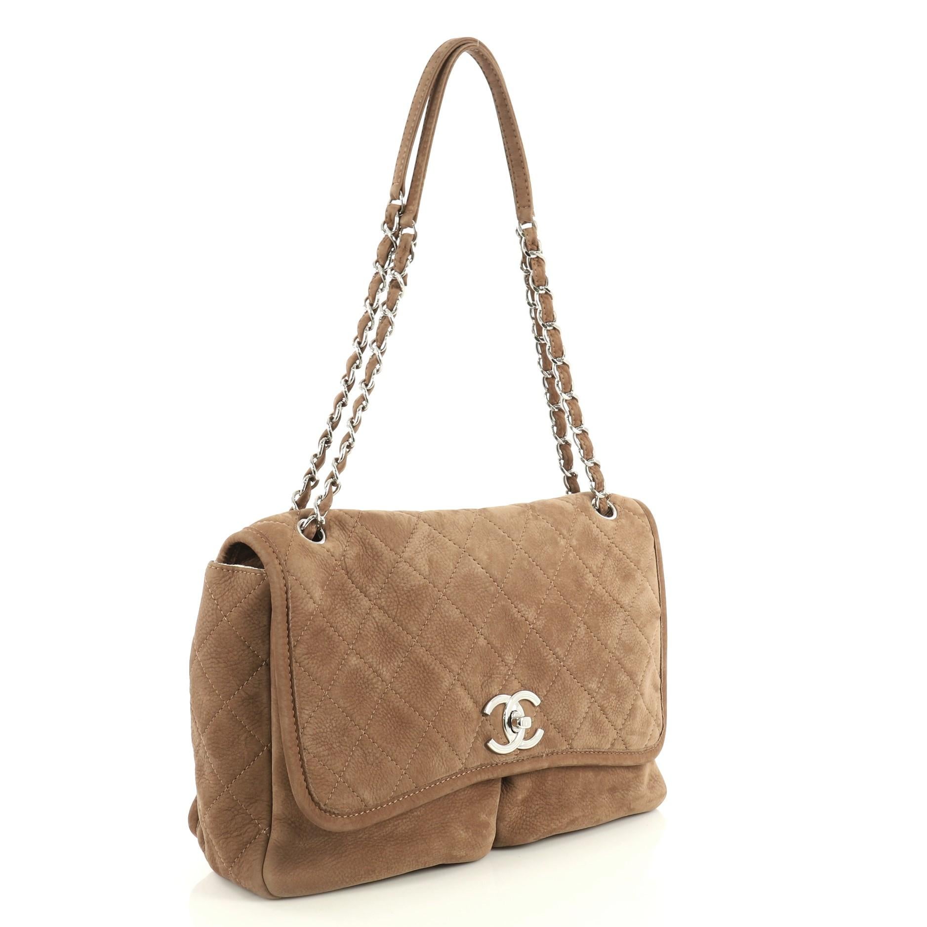 This Chanel Natural Beauty Split Pocket Flap Bag Quilted Nubuck Large, crafted in brown quilted nubuck, features woven-in leather chain straps, two slip pockets under flap and silver-tone hardware. Its CC turn-lock closure opens to a neutral fabric