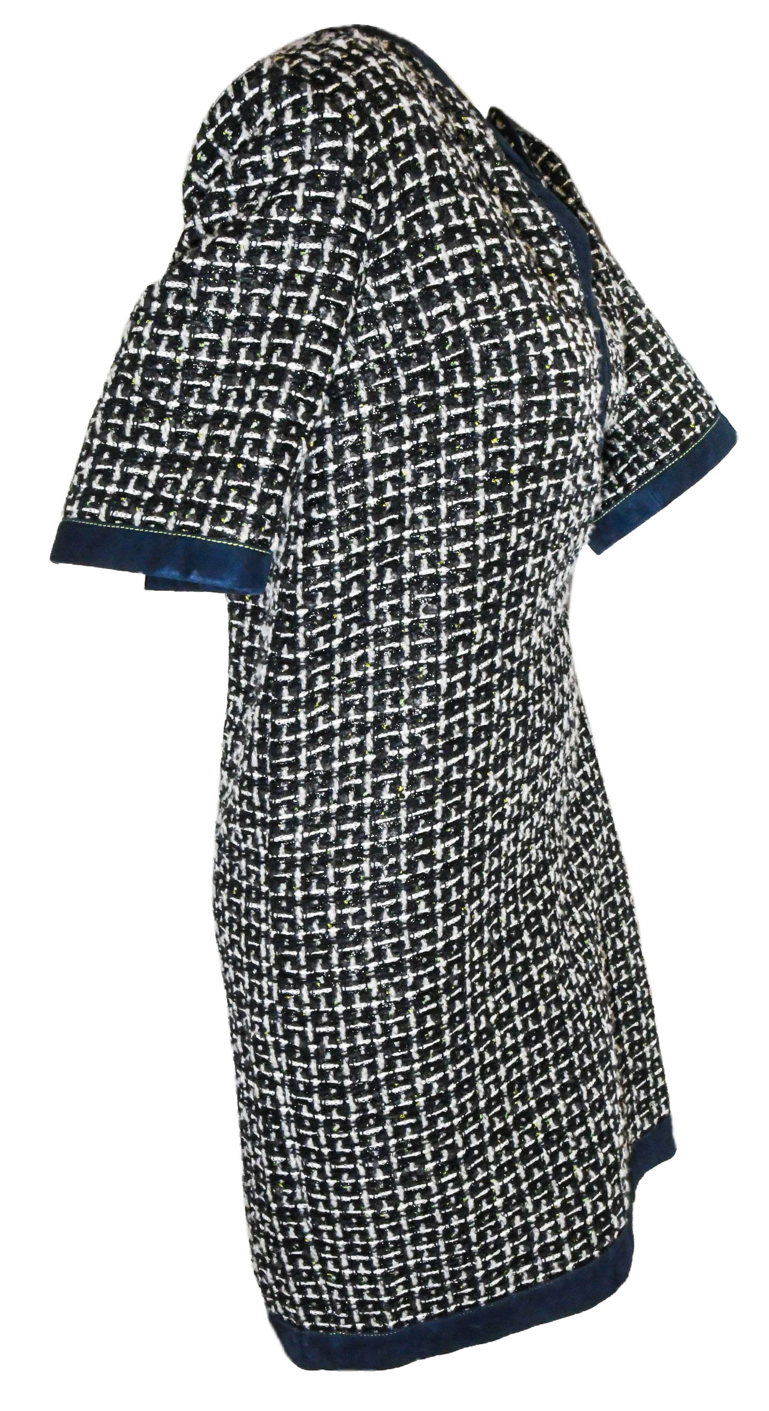 Chanel navy and white check tweed dress contains a lambskin suede trim a hem in deep blue for accent and, also, around the collar.  This dress includes one CC black gripoix plaque at the hip.  This dress is lined in blue camellia silk fabric.   The