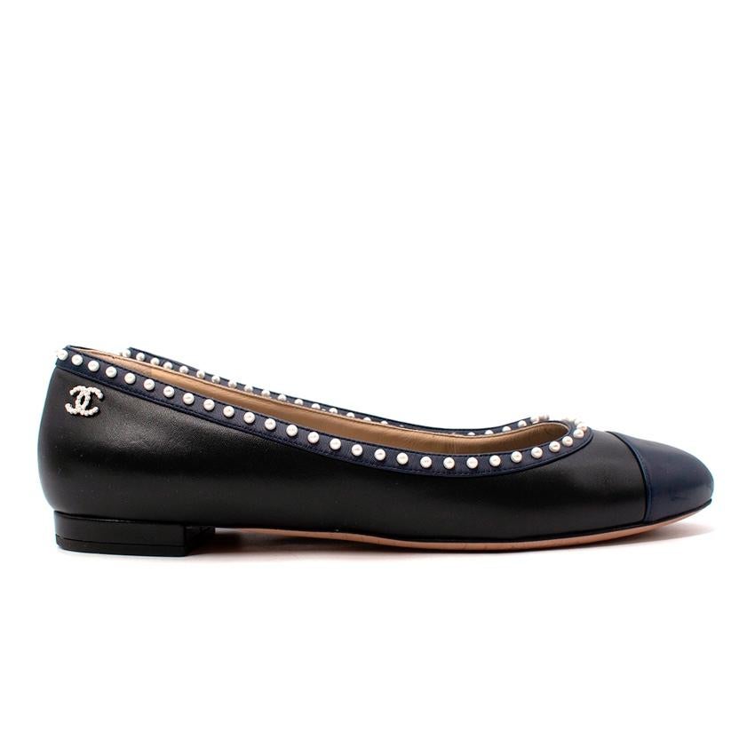 Chanel Navy & Black Faux-Pearl Trim Ballerinas
 

 - Black leather upper with contrasting navy toe cap and trim
 - Micro faux-pearls adorn the trim
 -CC faux pearl logo at the back 
 -Slip on 
 -Round toe 
 

 Materials 
 100% Leather 
 100% Faux