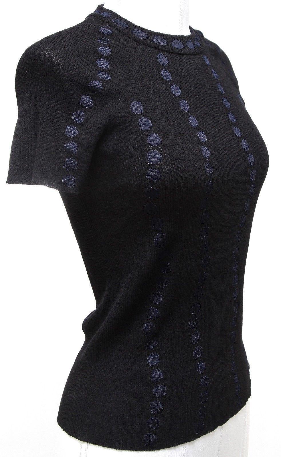 GUARANTEED AUTHENTIC CHANEL 2016 SPRING KNIT TOP
Retailed $1,250 + tax


Design:
 - Versatile short sleeve rib knit top in a rich black color with navy detail.
 - Polka dot pattern.
 - Crew neck.
 - Slip on.
 - CC logo at left hip.

Size: