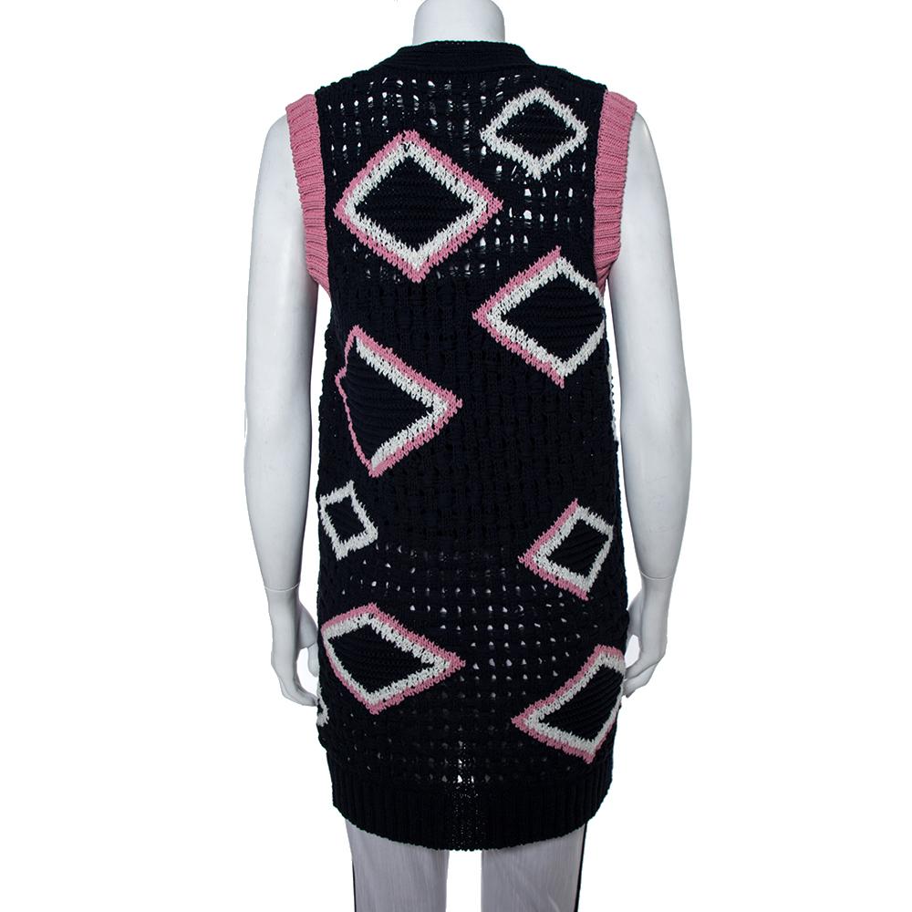 Created from a cotton blend, this classy cardigan by Chanel features a navy blue hue contrasted by a pink design all over Finished off with pockets and button fastenings, this sleeveless cardigan can be complemented by a turtle neck sweater dress