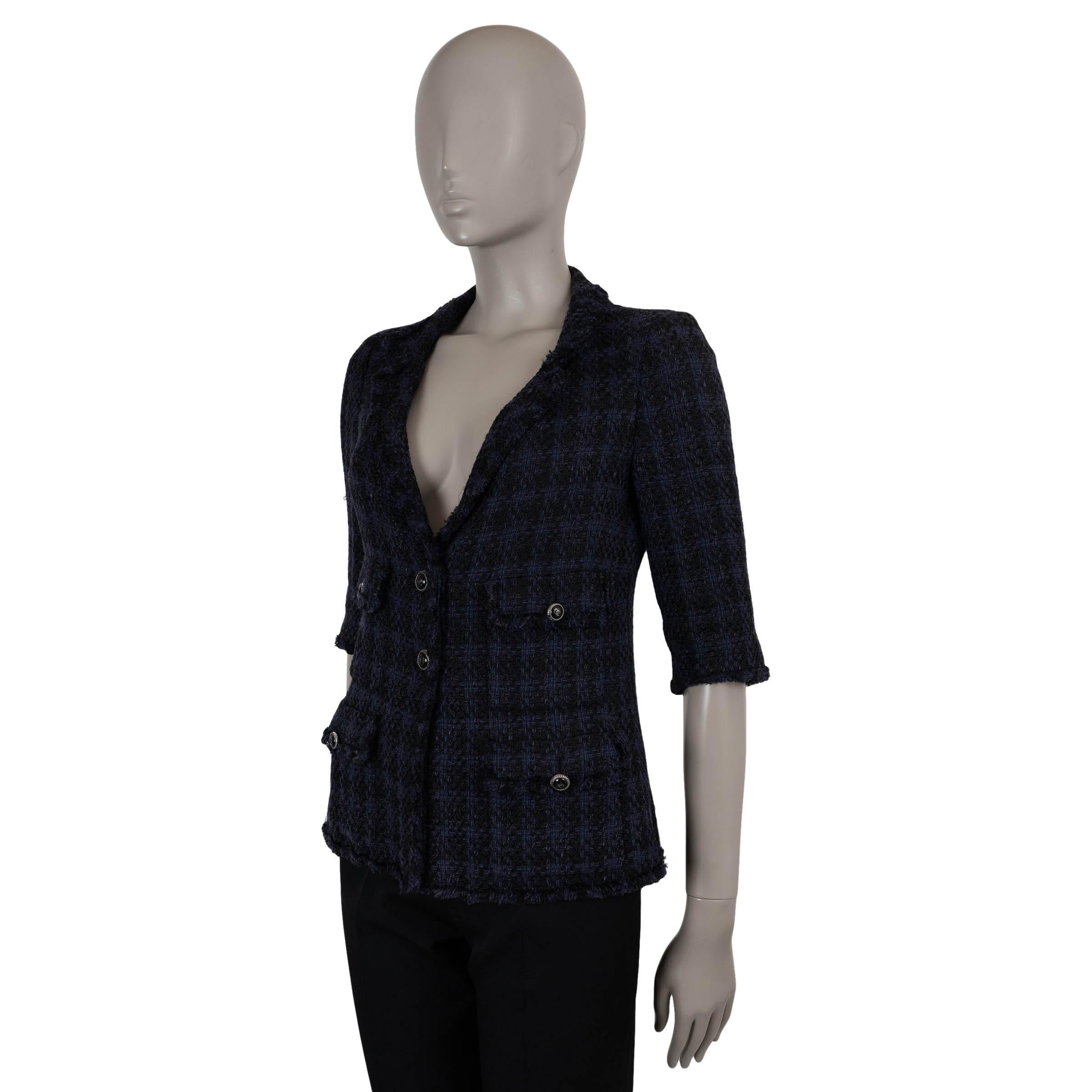 This 100% authentic Chanel jacket is crafted in navy blue and black tweed from a luxurious blend of viscose (42%), linen (35%), and cotton (23%). Designed with a classic silhouette, it features four front flap pockets with CC-adorned black round