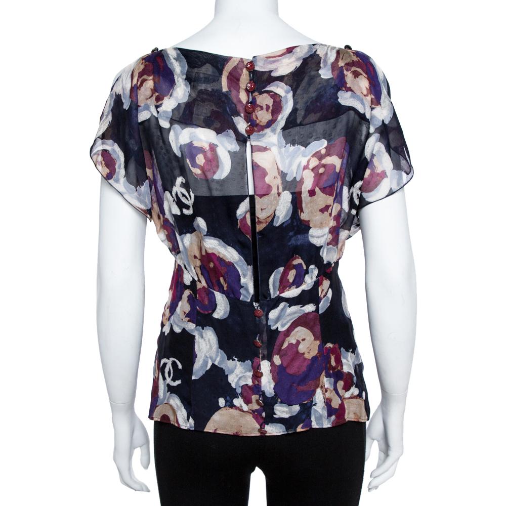 Diese Bluse von Chanel lässt Sie modisch göttlich aussehen. Die durchsichtige Bluse aus Seide ist mit Cutout-Details und dem charakteristischen Camellia-Druck versehen. Sie können es mit einem Camisole:: einer schmalen Hose und einem Paar High Heels