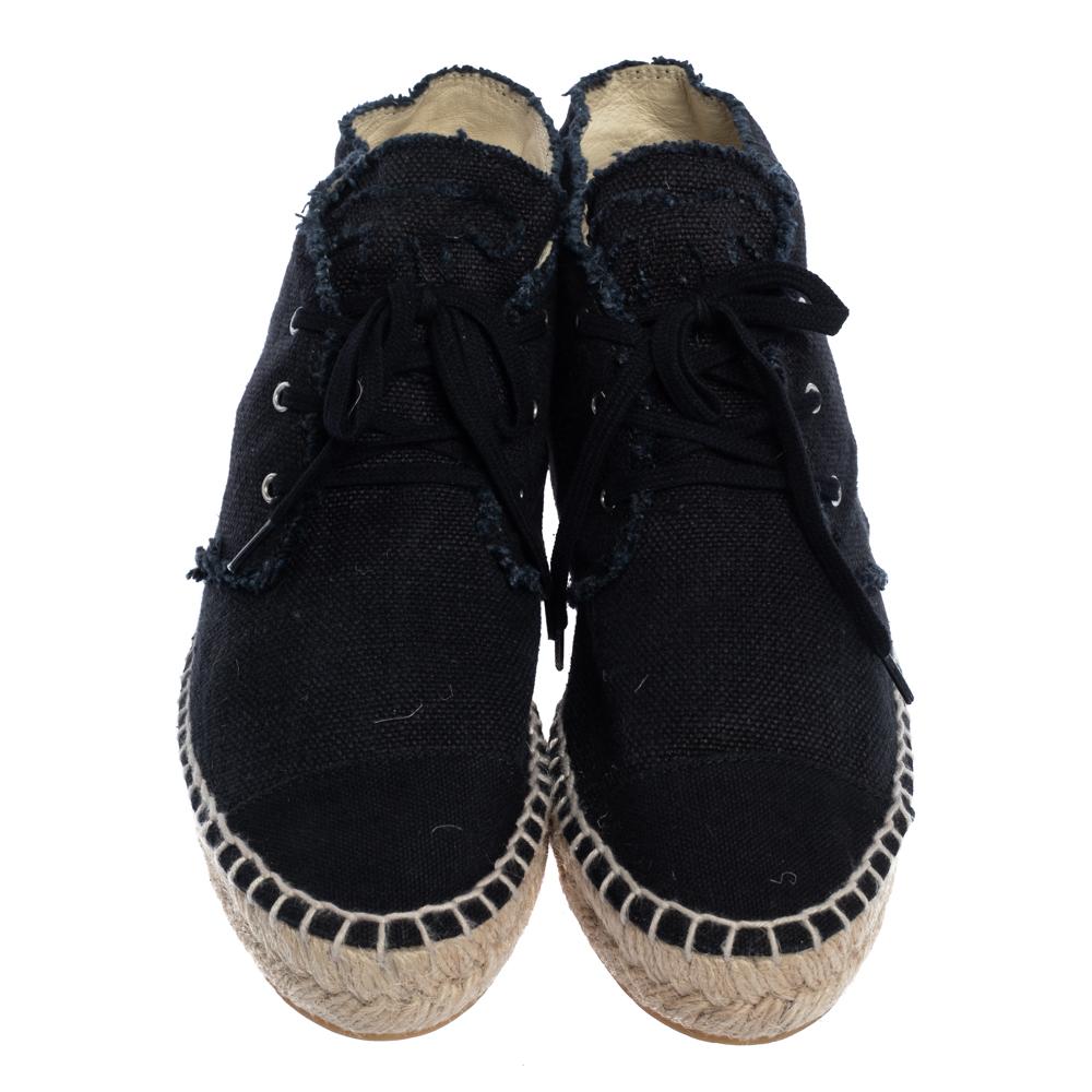 These classic flats by Chanel are a comfortable closet staple for any woman. These navy blue flats come crafted from canvas and feature a high-top style. They flaunt cap toes and lace-ups on the vamps and come equipped with leather-lined insoles and