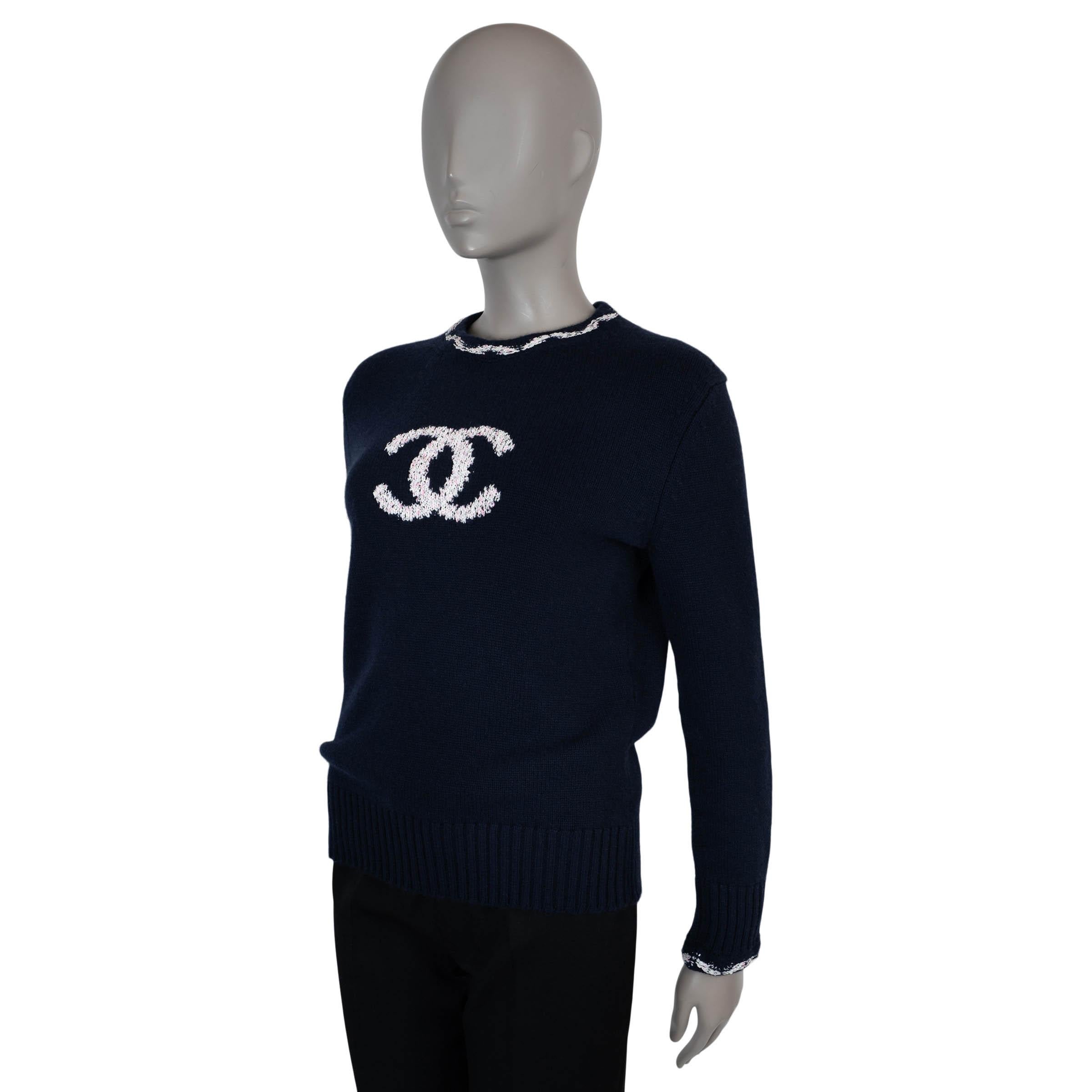 Este jersey 100% auténtico Chanel de cachemira azul marino (99%) y poliamida (1%) presenta un logotipo CC en jacquard en el centro en blanco moteado de rosa. Diseñado con un corte clásico, está acabado con ribetes de punto elástico y un ribete
