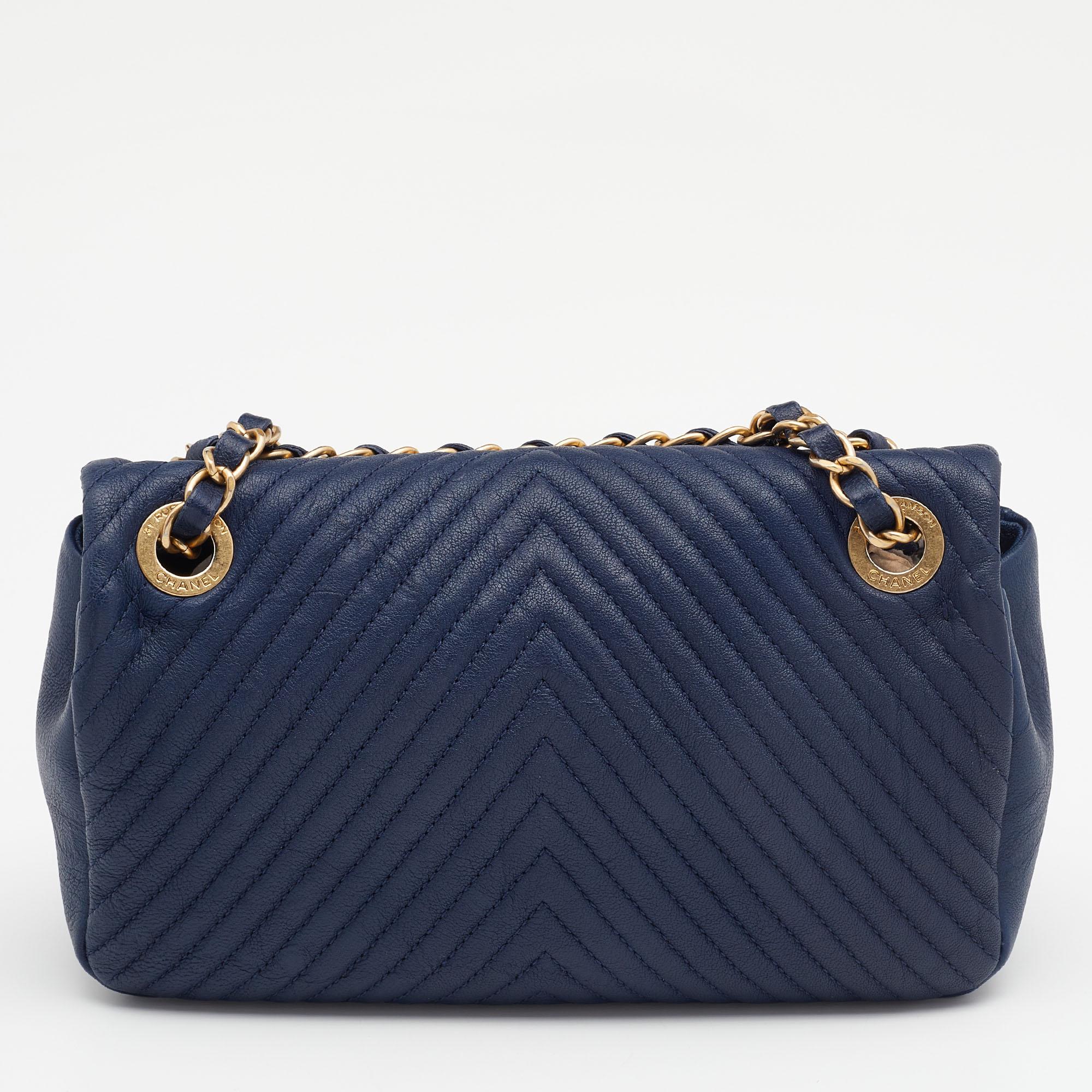 This Chanel flap bag is a favorite among fashionistas! Featuring the signature chevron pattern and the 'CC' logo on the leather exterior, this navy blue bag has a luxe look. Equipped with a chain-link strap and a spacious interior for all your