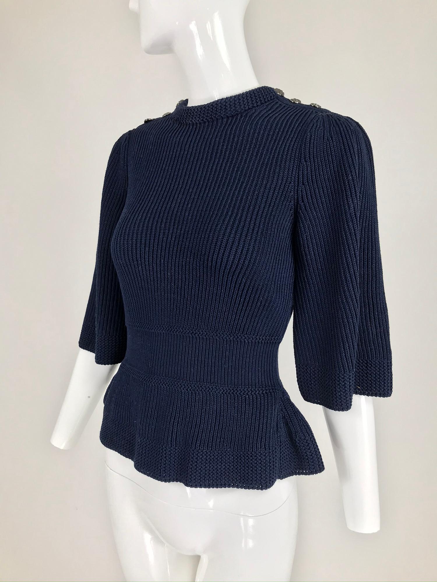 Chanel navy blue chunky cotton knit fitted waist peplum hem sweater with 3/4 length bell sleeves. This beautiful sweater has three working textured dark blue buttons on each shoulder. Marked size 36. Looks barely, if ever worn.
In excellent wearable