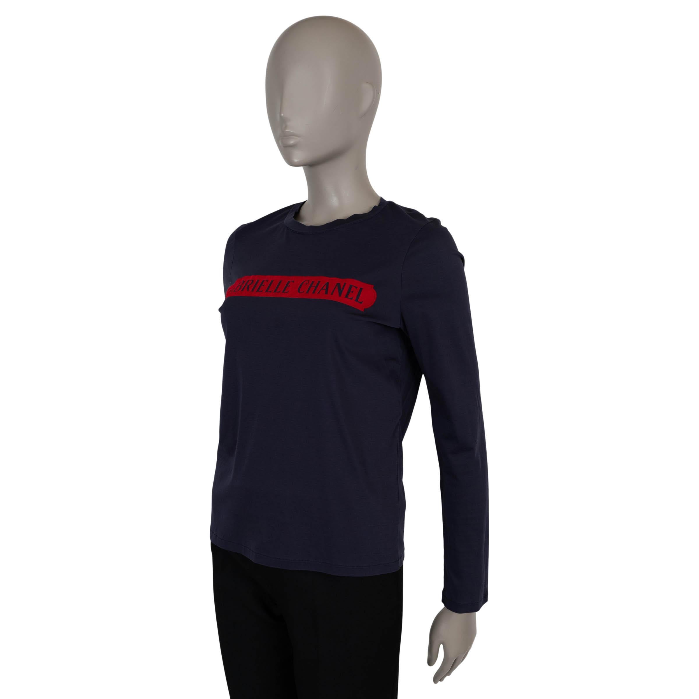 This 100% authentic Chanel long-sleeve T-shirt in navy blue jersey cotton (100%) features a bold red “Gabrielle Chanel” logo across the chest. Designed with a relaxed fit and classic crew neckline, it offers a casual yet iconic look. Has been worn