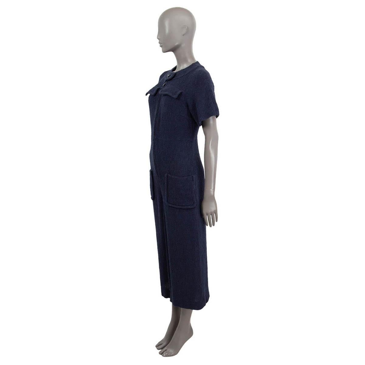 100% authentic Chanel 2016 short-sleeve wide-leg drop-crotch jumpsuit in navy blue cotton (90%) and nylon (10%) tweed with a navy blue silk (100%) lining. The design has a round collar with button detail and opens with a zipper at front. Two patch