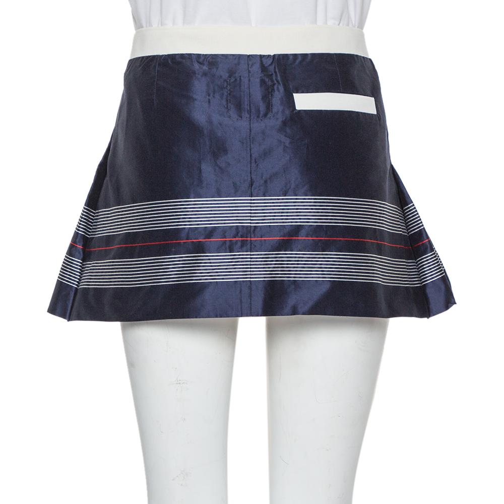 This preppy Tennis skirt by Chanel is a great pick for your sporty ensembles. Crafted from cotton & silk, it has a navy blue exterior and comes with stripe details. The pleats add a classic touch while the zip secures it well. Pair with a polo