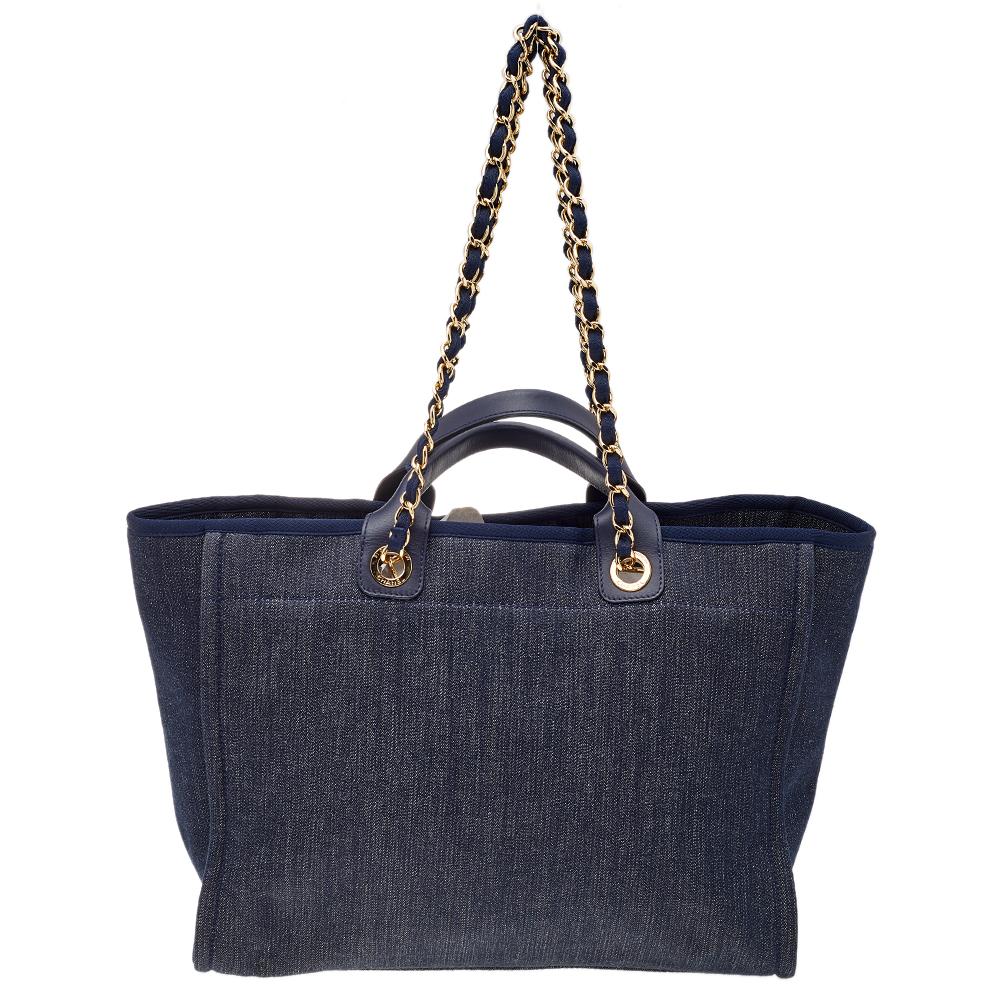 To carry it to the beach or off-duty, this multipurpose bag comes in handy for any casual event. This Chanel Deauville tote bag is crafted in denim and leather in a versatile navy blue hue. This bag features a large slip pocket with wall pockets and