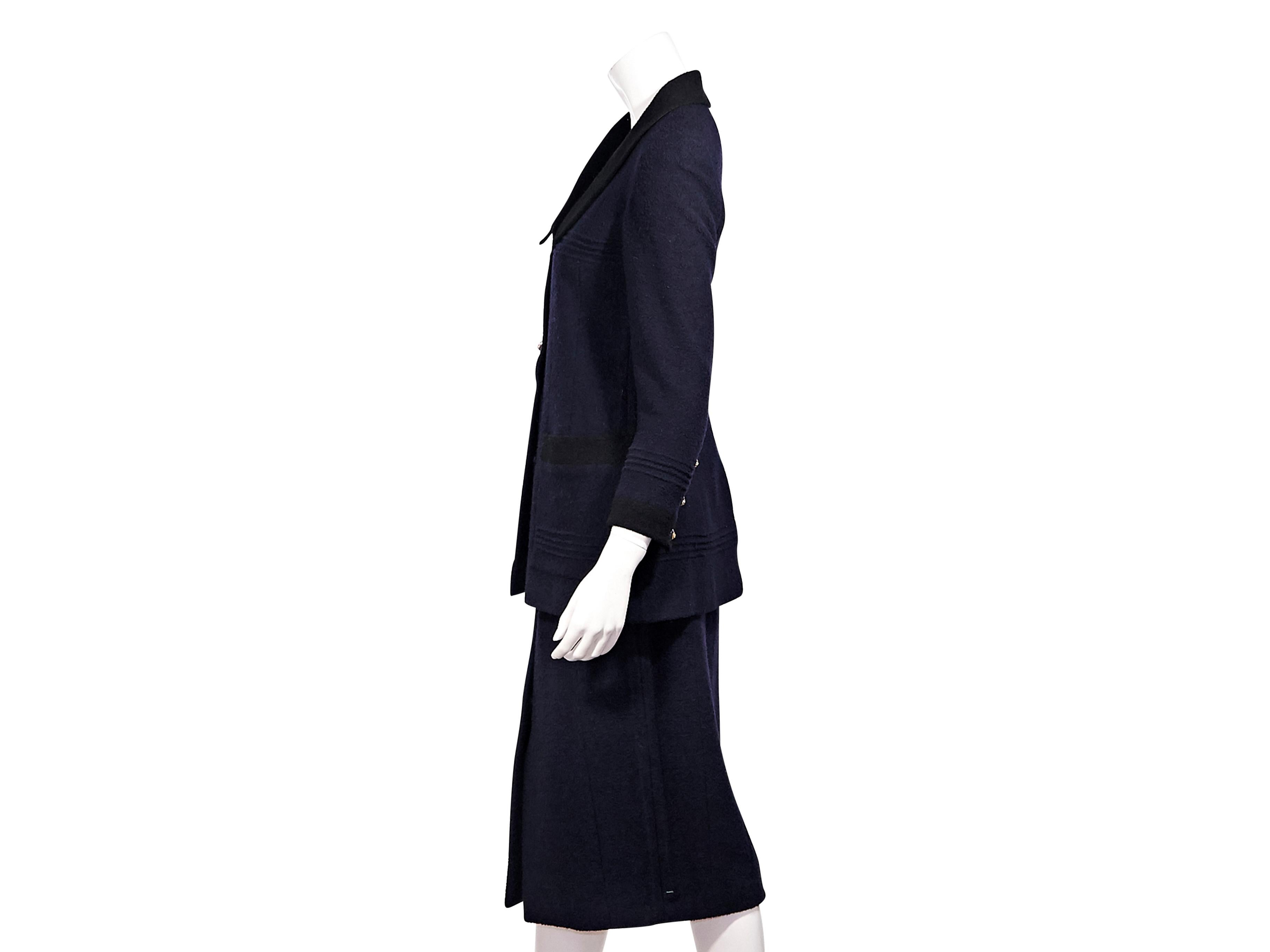 Product details:  Vintage navy blue boucle wool skirt suit set by Chanel.  From the Fall/Winter 1993 collection.  Long sleeves.  Three-button detail at cuffs.  Button-front closure.  Back center hem vent.  Matching skirt.  Banded waist. 