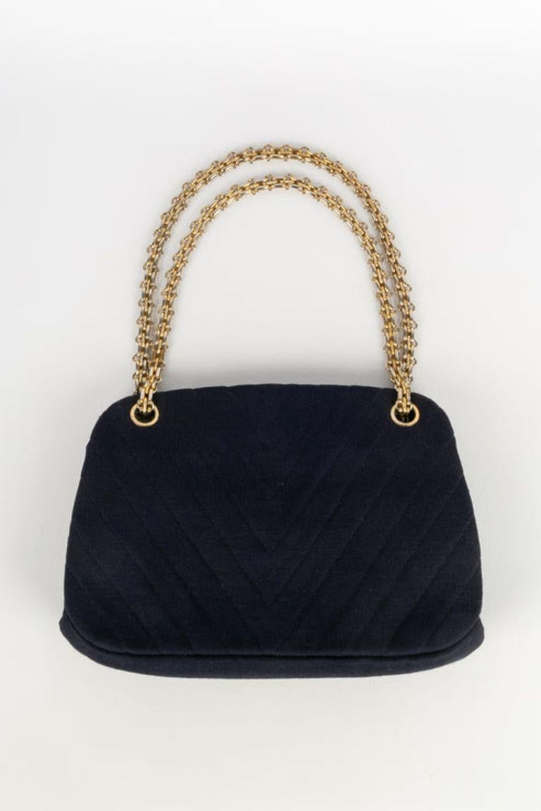 Chanel -Bag in navy blue jersey and red interior. Gold metal attributes. No serial numbers.

Additional information: 
Dimensions: Height: 26 cm, Length: 17 cm, Depth: 6 cm, Handle: 68 cm
Condition: Good condition
Seller Ref number: S9