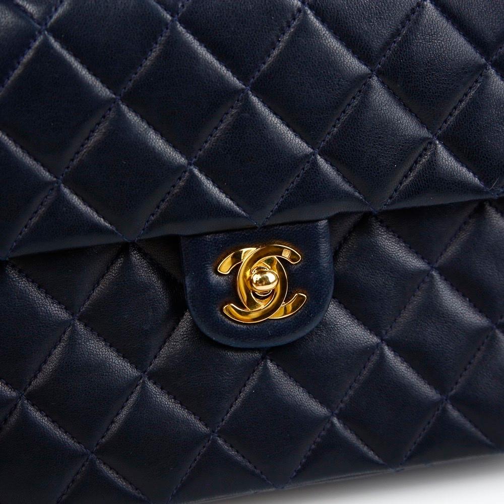 Chanel Navy Blue Lambskin Small Square Vintage 90s Classic Flap Bag 

Year: 1989-1991

Gold hardware
CC Turn Lock Closure 
Classic Interwoven Chain
Single Shoulder Strap
Navy Blue Lambskin Leather
Large CC Logo Stitched Under Flap
Burgundy Leather