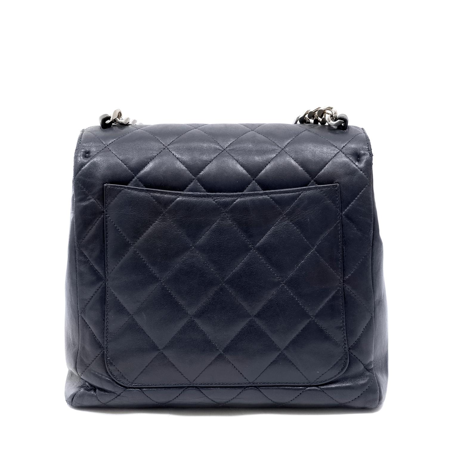 This authentic Chanel Navy Leather Chain Strap Flap Bag is in very good early vintage condition.  A rare find, it is a must have for collectors.
Navy blue leather is quilted in signature Chanel diamond pattern.  Large interlocking CC is stitched on