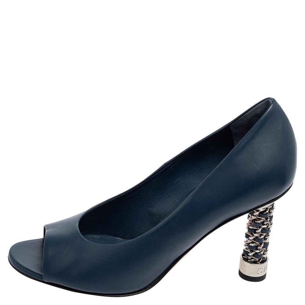 These Chanel pumps are the definition of chic. They are made from navy blue leather and support a peep-toe design. They stand tall with 10 cm heels and are embellished with silver-tone metal featuring the CC logo on the heels.