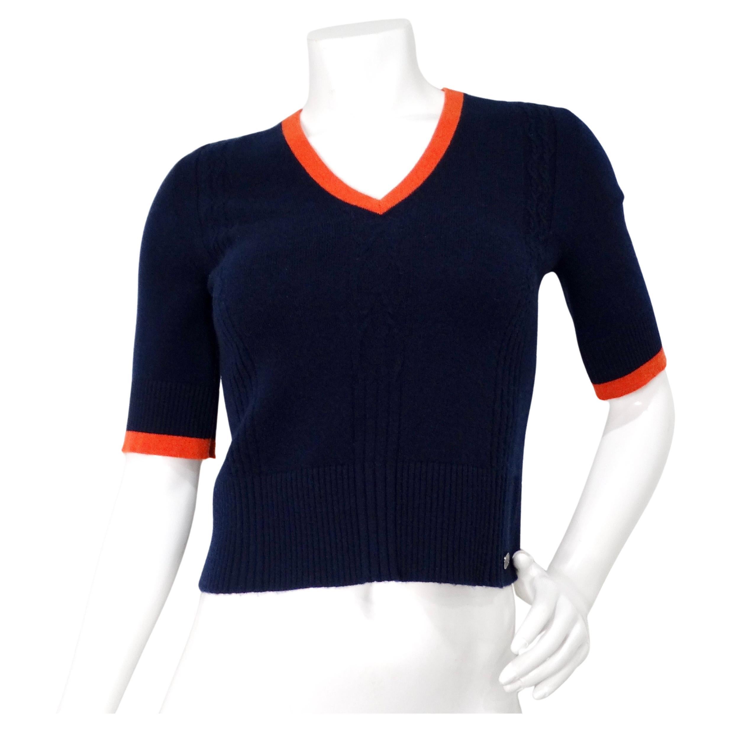Il top Chanel con scollo a V in cashmere blu e arancione emana un'eleganza sofisticata grazie al suo lussuoso tessuto in cashmere, che offre comfort e stile. Il profondo blu navy funge da base senza tempo, accentuato splendidamente da un orlo