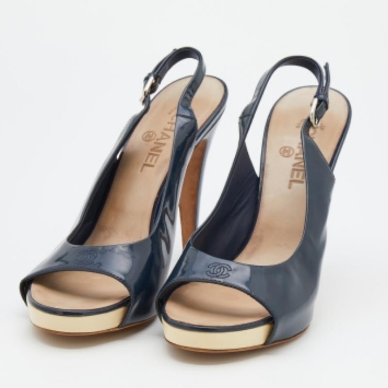 Offering comfort with elegance, these Chanel slingback buckled sandals are a wardrobe essential. Crafted in navy blue patent leather, the open toe features a platform. The pumps have insole lining that profiles the brand's signature and are complete