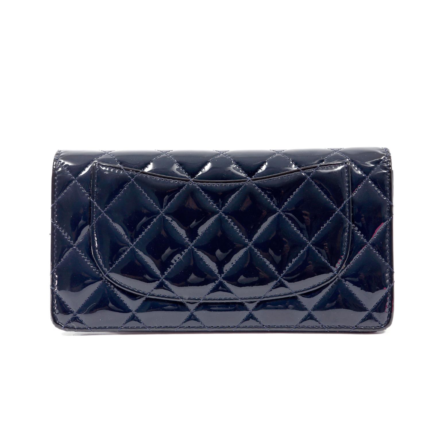 Questo autentico portafoglio Chanel in pelle verniciata blu navy è in condizioni immacolate.  Organizza con stile la tua valuta, le tue carte e le tue monete con questo resistente e pratico Chanel.
La vernice blu navy è trapuntata con il