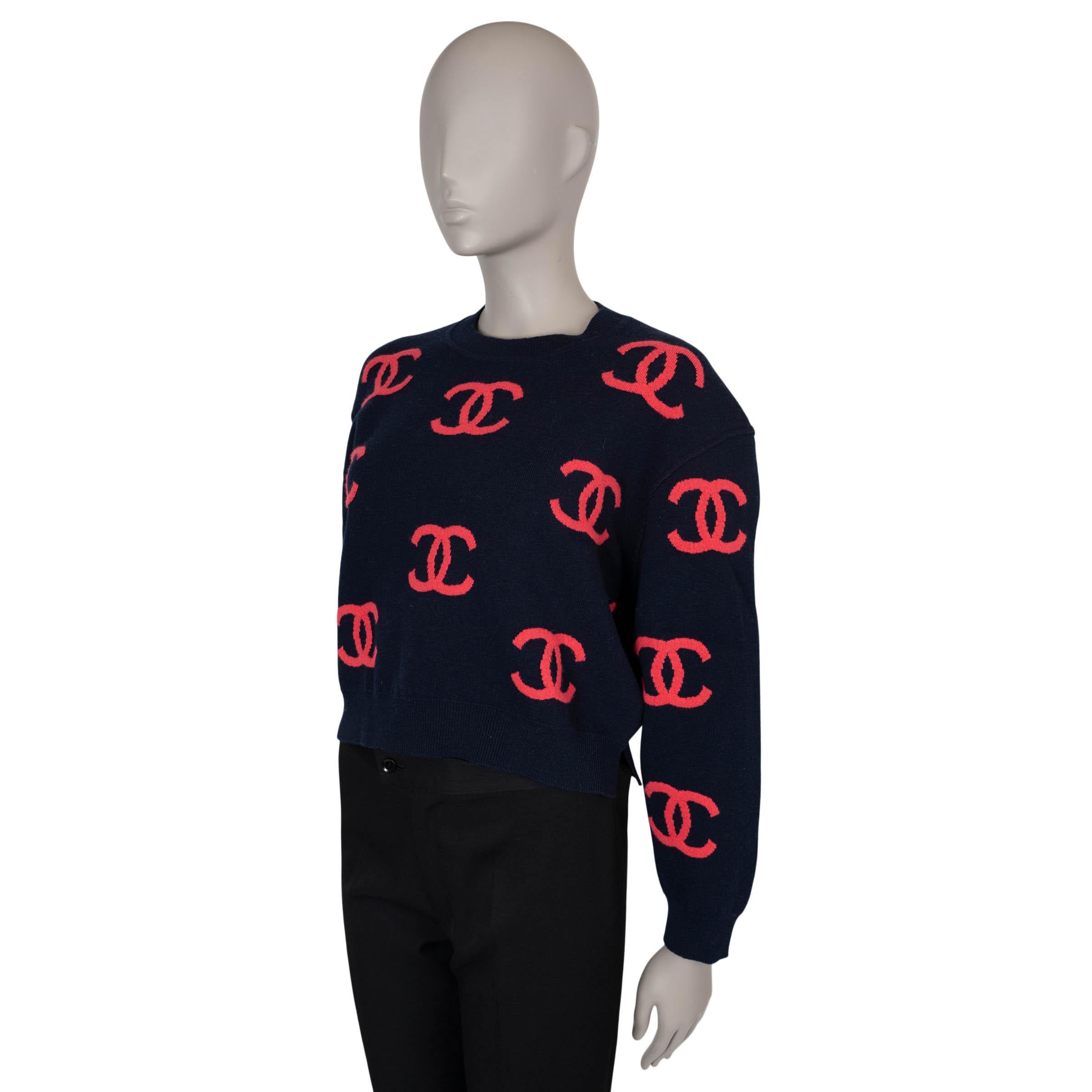 This 100% authentic Chanel logo jacquard sweater is crafted from navy blue and pink cashmere (with 3% elastane), offering a soft, luxurious feel. It features a cropped, boxy silhouette with dropped shoulders, a classic crewneck, and rib-knit trims,