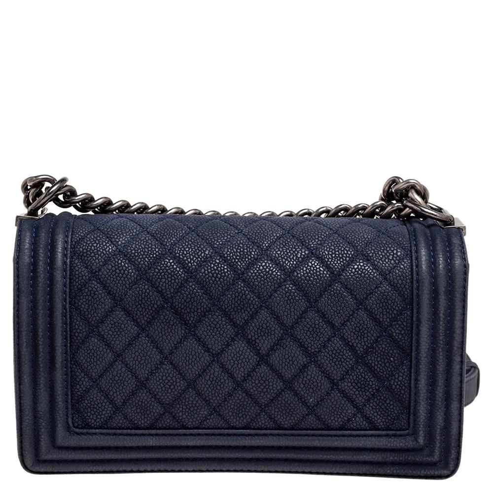 This medium Boy Flap bag from the House of Chanel is truly a pièce de résistance in the world of luxury fashion. It is crafted using navy-blue quilted Caviar leather with a gunmetal-toned CC accent placed on the front. This bag is held by a sturdy