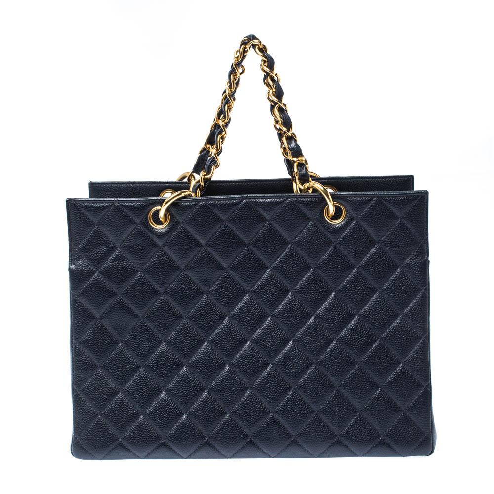 Featuring leather woven chain handles and the iconic CC logo on a quilted pattern, this Chanel navy blue Caviar leather shopper tote exudes timeless beauty. The bag features a capacious compartment and gold-tone hardware finishing. This piece is