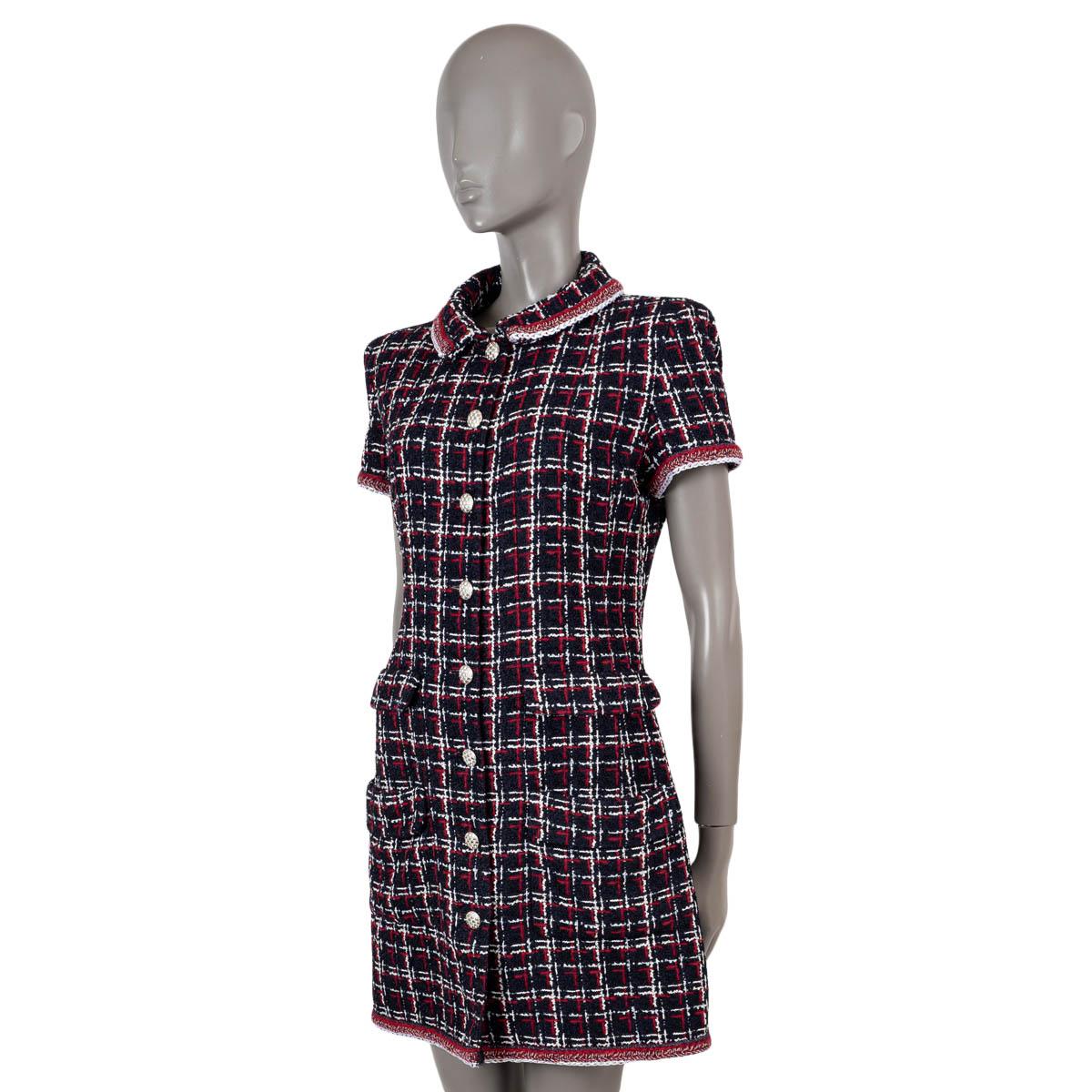100% authentic Chanel short sleeve tweed shirt dress in navy blue, red and white viscose (50%), linen (22%), polyamide (17%) and cotton (11%). Features braided trims and four flap pockets at the waist. Opens with rhinestone encrusted buttons on the
