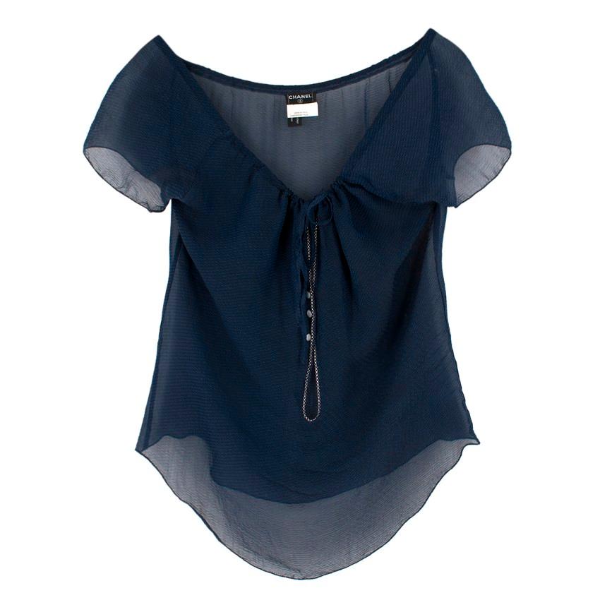 Chanel Navy Blue Silk Sheer Blouse

-Navy blue, 100% silk
-Adjustable rope tie neckline
-Swoop neckline 
-Sheer top
-Buttoned closure at front with key hole opening 
-Decorative sliver chain detail around front buttons 
-Frilled hem on sleeves