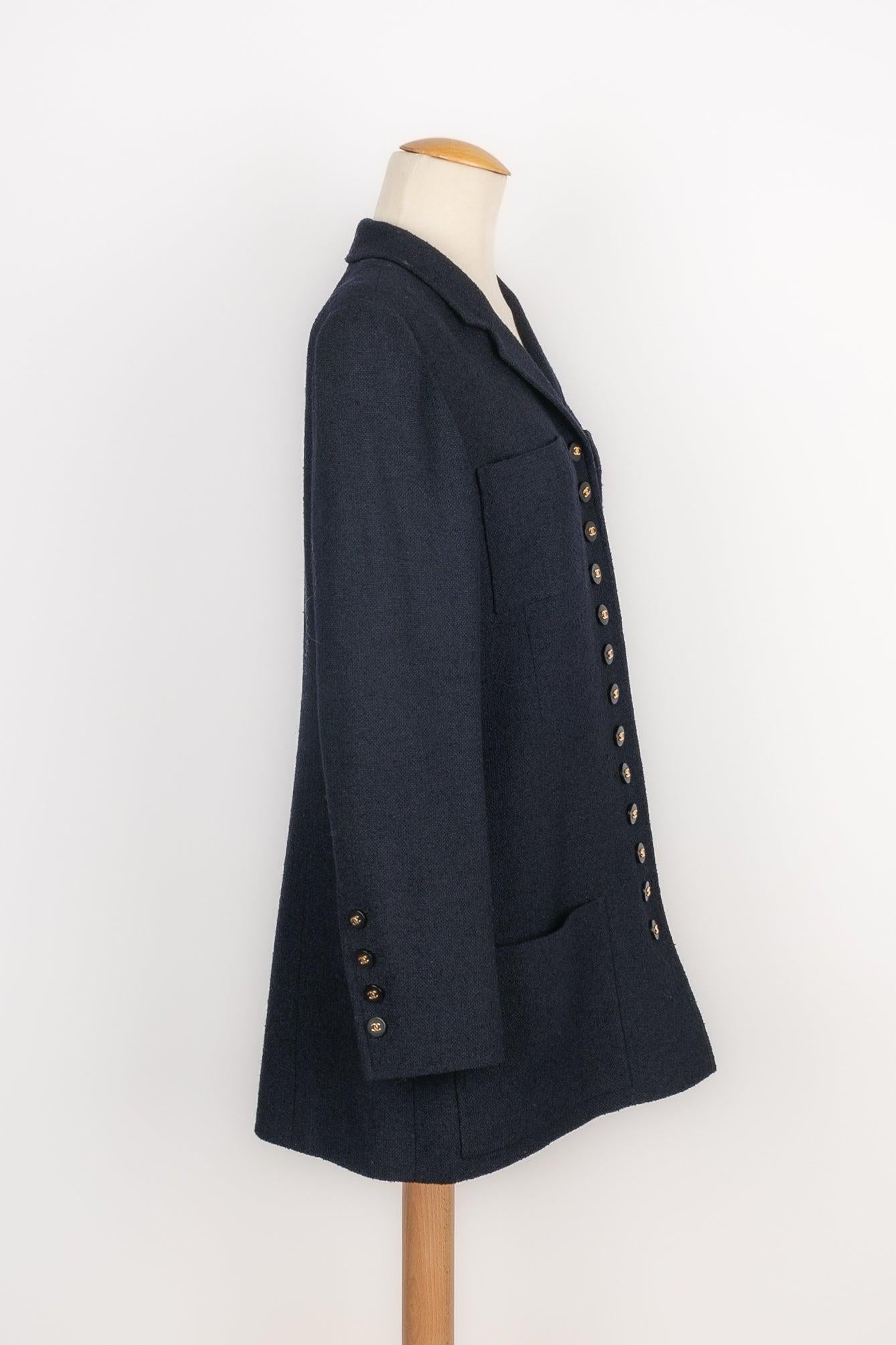 Chanel - (Made in France) Navy-blue tweed jacket with a silk lining. Black bakelite buttons topped with golden metal cc logos. Size 44FR indicated. 1996 Spring-Summer Collection, under the artistic direction of Karl Lagerfeld.

Additional