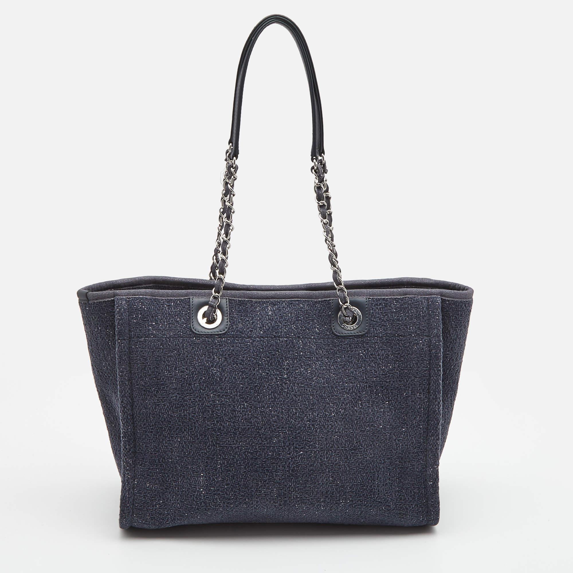 To carry it to the beach or off-duty, this multipurpose bag comes in handy for any casual event. This Chanel Deauville tote bag is crafted in tweed in a versatile navy blue hue. This bag features a large slip pocket with wall pockets and magnetic