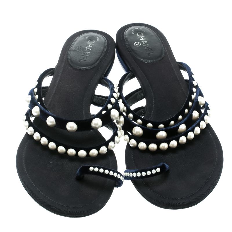 How gorgeous are these navy blue slides from Chanel! They have been crafted from velvet in a strappy layout and flaunt faux pearls embellished on the straps. They come equipped with comfortable insoles and feature the iconic CC logo at the back.