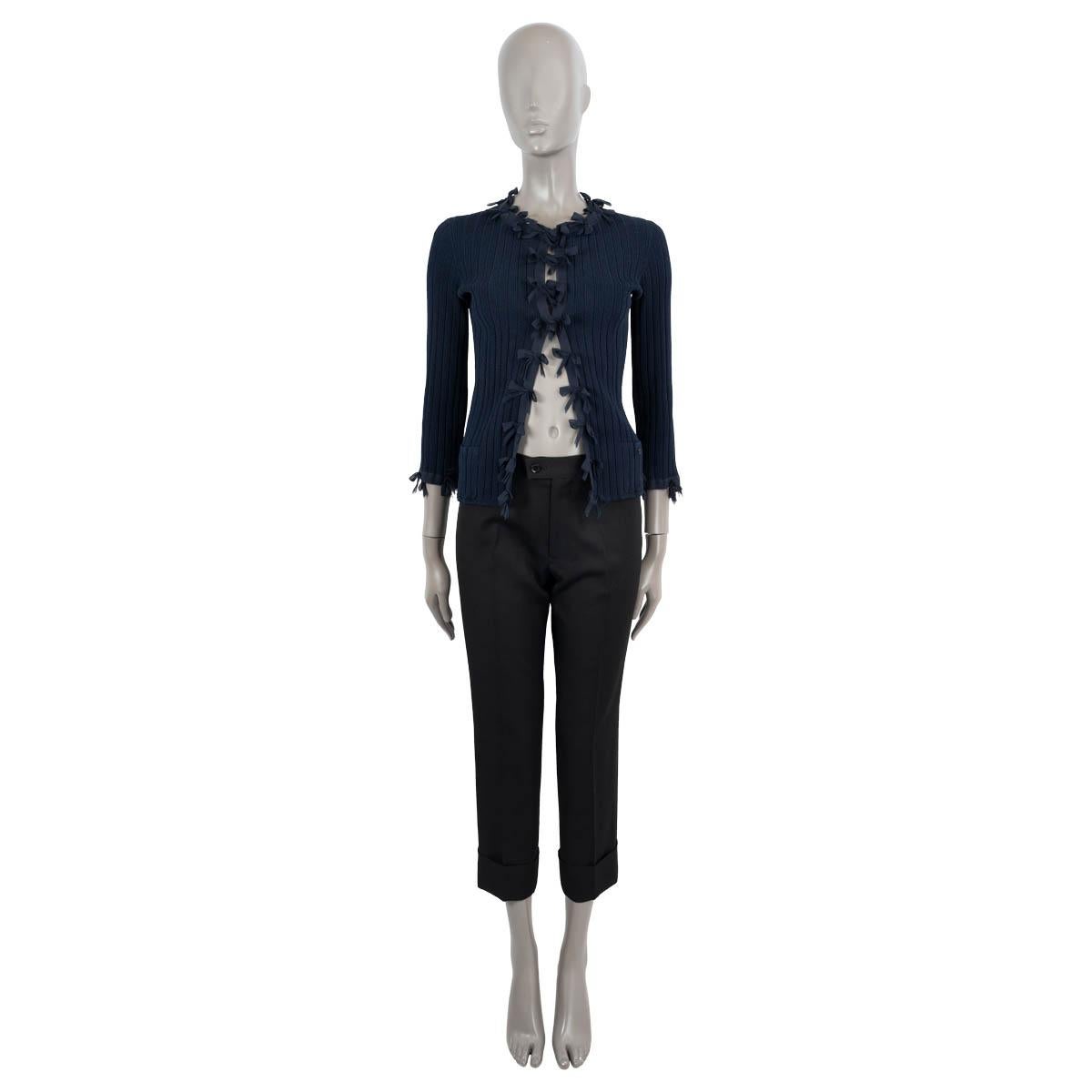 100% authentic Chanel rib-knit cardigan in navy blue viscose (76%) and elastane (24%). Features bow trim, 3/4 sleeves and patch pockets. Closes with hooks on the front. Unlined. Has been worn and is in excellent condition.

2006 Spring/Summer