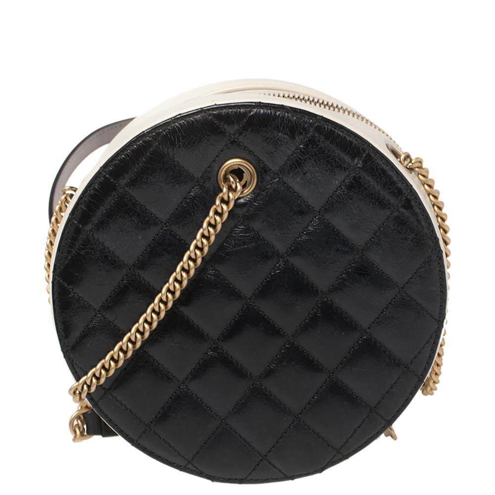 A part of Chanel's Cruise 2019 collection, this En Vogue bag is lovely. Crafted from black leather, this round-shaped bag carries the iconic CC logo and a robe detailing on the front, the signature quilts on the rear, and contrasting white contours.