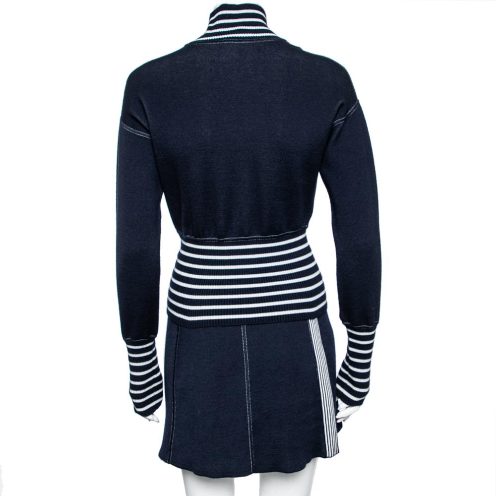 With this jumper and skirt set from the house of Chanel, your winter styles will look more fashionable and chic! This set is tailored using navy-blue and white striped knit fabric. The jumper flaunts plane embellishments, long sleeves, and a turtle